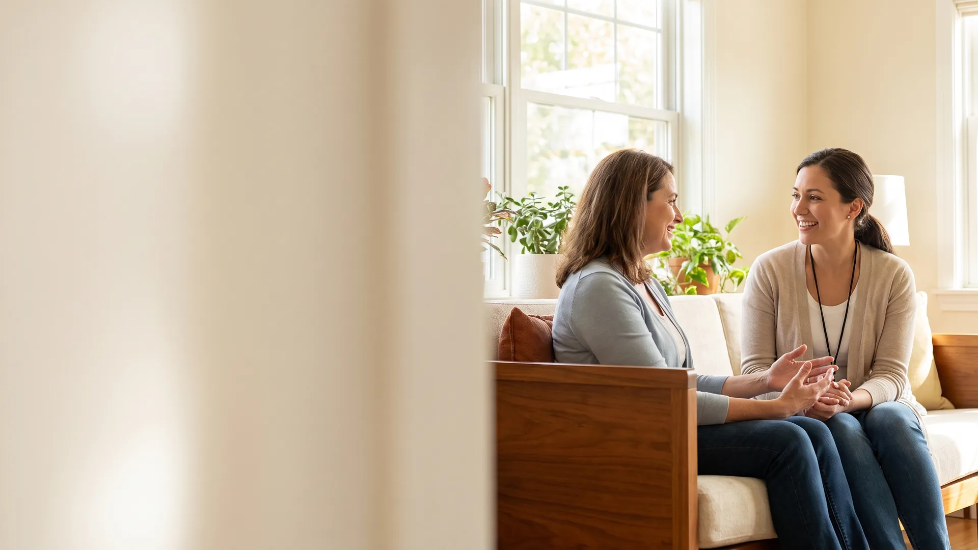 Two women having a friendly conversation in a bright residential setting